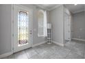 Elegant foyer featuring tile flooring, a decorative glass front door, and a arched window at 1009 Birch Hollow Dr, Apopka, FL 32703