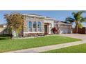 Charming single-story home with stone facade, manicured lawn, and brick-paved driveway at 1009 Birch Hollow Dr, Apopka, FL 32703