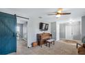 Open living room featuring a flat screen TV, piano, and a barn door to another room at 104 Cambridge Dr, Longwood, FL 32779