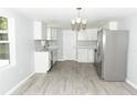 Bright, remodeled kitchen featuring white cabinets, stainless steel appliances, and contemporary gray wood flooring at 1350 Martin Luther King Jr Blvd, Bartow, FL 33830