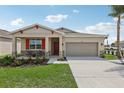 Charming single-Gathering house with a welcoming front porch, stone accents, and a well-manicured lawn at 1355 Wood Line Loop, Deland, FL 32720