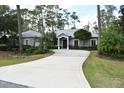 Charming single story home featuring a curved driveway, mature trees, and manicured landscaping at 14641 Henson Rd, Orlando, FL 32832