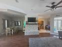 Open-concept living room with a stone fireplace, dining area, hardwood floors, and a ceiling fan at 14641 Henson Rd, Orlando, FL 32832