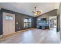 Inviting living room featuring gray walls, light wood floors, a modern ceiling fan, and a large window at 1510 Chatsworth Ave, Deltona, FL 32738