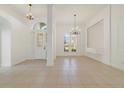 Bright living room with tile flooring, decorative lighting fixtures, and transom window above front door at 1521 Gants Cir, Kissimmee, FL 34744
