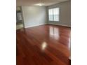Bright living room featuring gleaming hardwood floors and a large window for natural light at 15279 Sugargrove Way, Orlando, FL 32828