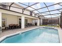 Relaxing backyard oasis with a screened-in pool, hot tub, patio, and outdoor dining area at 2320 Lelani Cir, Davenport, FL 33897