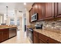 Well-equipped kitchen featuring stainless steel appliances, dark wood cabinets and granite countertops at 2956 Falconhill Dr, Apopka, FL 32712