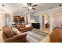 Inviting living room with tan sofas, tile floors, ceiling fan and an open floorplan with views into the kitchen at 2956 Falconhill Dr, Apopka, FL 32712