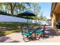 Outdoor patio featuring brick pavers, shade umbrella, dining table and a manicured lawn at 2956 Falconhill Dr, Apopka, FL 32712