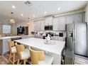 Modern kitchen boasts gray cabinets, stainless steel appliances, a large island, and stylish pendant lighting at 3055 Aqua Virgo Loop # 47, Orlando, FL 32837
