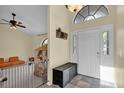 Bright foyer featuring tile floors, a high ceiling, and a decorative transom window above the front door at 322 Harbor Trl, Enterprise, FL 32725