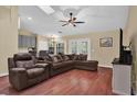 Spacious living room with hardwood floors, a ceiling fan, and French doors leading to the backyard at 322 Harbor Trl, Enterprise, FL 32725