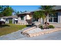 Well-maintained front yard with a stone pathway and colorful landscaping and a walkway to the front door at 345 W Seminole Ave, Eustis, FL 32726