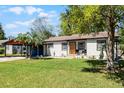 Beautiful one-story home showcasing a bright orange door and a well-maintained yard, providing a welcoming curb appeal at 407 E Jersey St, Orlando, FL 32806