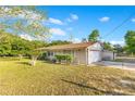 Charming single-story home featuring a spacious front yard, attached garage, and mature trees at 4550 Chandler Rd, Apopka, FL 32712