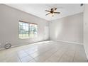 Spacious living room features ceramic tile floors, fresh paint, and large window at 4751 Deer Run Rd, St Cloud, FL 34772