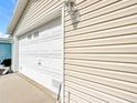 Attached one-car garage with white door and light fixture offering convenient parking and storage at 480 Hildalgo Dr, The Villages, FL 32159