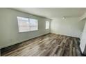 Spacious living room featuring modern wood-look flooring, light walls, and two windows at 5317 Curry Ford Rd # O201, Orlando, FL 32812