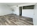 Open living area with wood-look floors, white appliances, and a pass-through window to another space at 5317 Curry Ford Rd # O201, Orlando, FL 32812