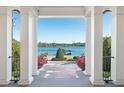 A view from the front porch with white columns, showcasing the lake view and boat dock at 571 N Lake Sybelia Dr, Maitland, FL 32751