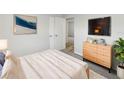 Bright bedroom featuring neutral walls, soft carpet, a dresser, and a wall-mounted television at 6003 W Harwood Ave, Orlando, FL 32835