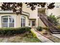 Building exterior features a staircase, well-maintained landscape, and covered entryway at 696 Seabrook Ct # 101, Altamonte Springs, FL 32714