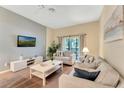Comfortable living room featuring stylish furniture, neutral tones, and a sliding door to the balcony at 806 Lucaya Loop, Davenport, FL 33897