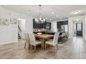 Open-concept kitchen and dining area with dark cabinetry, stainless appliances, and modern lighting at 8366 Randal Park Blvd, Orlando, FL 32832