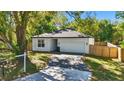 Inviting single-story home with brick-paved driveway, lush trees, and a two-car garage enhances curb appeal at 851 W 24Th Pl, Sanford, FL 32771