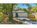 Well-maintained single-story home with a paved driveway, lush greenery, and an attached two-car garage at 851 W 24Th Pl, Sanford, FL 32771