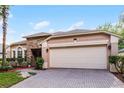Inviting home with a stone accent wall, neutral paint, a large garage, and a neatly paved driveway at 9054 Sandwood Way, Orlando, FL 32832