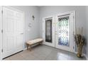 Bright foyer featuring decorative doors, tile flooring, a bench, and tasteful decor at 9054 Sandwood Way, Orlando, FL 32832
