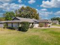 Charming single-story home with a well-manicured lawn, shrubbery, and stone accents under a bright sky at 9501 Holbrook Dr, Orlando, FL 32817