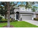 Charming two-story home with well-manicured lawn and attached two-car garage at 9899 Leland Dr, Orlando, FL 32827