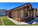 Well-maintained tan home with brick accents, a red door, and a nicely landscaped front yard at 10020 Creekwater Blvd, Orlando, FL 32825
