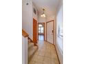 Inviting foyer with tile flooring, staircase, and view into the adjacent living area at 10020 Creekwater Blvd, Orlando, FL 32825