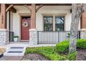 Close-up of a townhouse front porch with stone pillars and a welcoming red door at 10655 Village Lake Rd, Windermere, FL 34786
