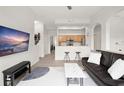 Open-concept living room featuring a mounted TV, a comfortable sofa, and a kitchen view at 12016 Villanova Dr # 101, Orlando, FL 32837