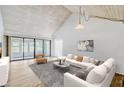 Bright living room featuring a vaulted ceiling, sliding glass doors, and stylish contemporary furnishings at 1236 Villa Ln # S, Apopka, FL 32712