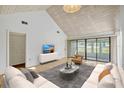 Bright living room featuring a vaulted ceiling, sliding glass doors, and stylish contemporary furnishings at 1236 Villa Ln # S, Apopka, FL 32712