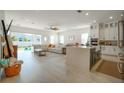 Bright, open living space with a large sectional sofa, kitchen island, and sliding glass doors to the backyard at 13301 Mcmillan Dr, Orlando, FL 32827