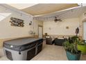 Relaxing covered patio with hot tub, comfortable seating, plants and decorative lighting at 13326 Fountainbleau Dr, Clermont, FL 34711