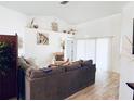 Bright living room with neutral walls, wood-look flooring, and slider doors at 13405 Sw 86Th Ave, Ocala, FL 34473