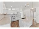 Bright kitchen with white cabinets, stone countertops, stainless steel appliances, and tile backsplash at 15746 Autumn Glen Ave, Clermont, FL 34714