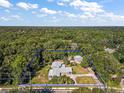 An aerial view of a gray single Gathering home surrounded by lush trees with a blue line surrounding property at 1661 Votaw Rd, Apopka, FL 32703