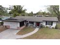 Aerial view of a charming single-story home with a well-maintained lawn, red door and brick accents at 1938 Eastbrook Blvd, Winter Park, FL 32792