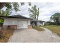 A single-story house with a two-car garage and brick-lined driveway, leading to the front door at 1938 Eastbrook Blvd, Winter Park, FL 32792
