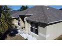 A well-maintained single Gathering home with a beige exterior, dark-framed windows, and tidy, white rock landscaping at 1956 Myakka Ct, Poinciana, FL 34759