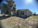 Exterior shot of a single-Gathering home with a palm tree, tidy landscaping, and a well-maintained lawn at 1956 Myakka Ct, Poinciana, FL 34759